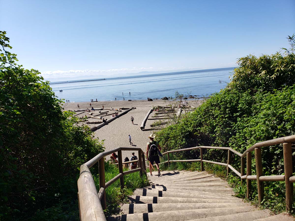 A visitor descending the wooden stairs toward Wreck Beach.