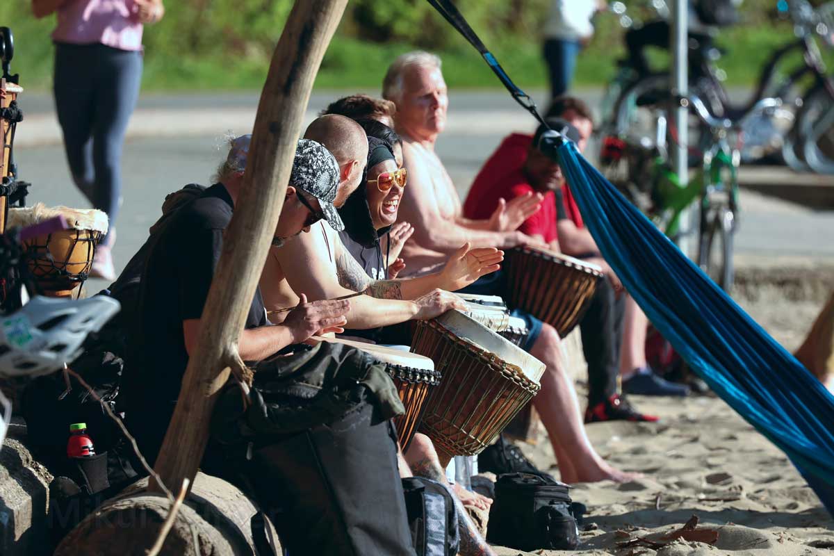 People drumming together and enjoying music at Third Beach