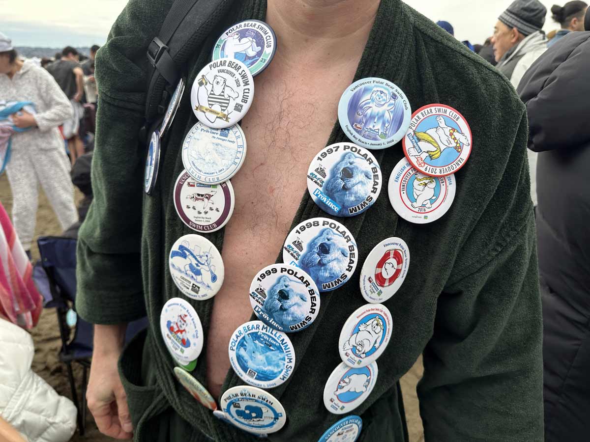 Polar Bear Swim participant showing off a collection of event badges.