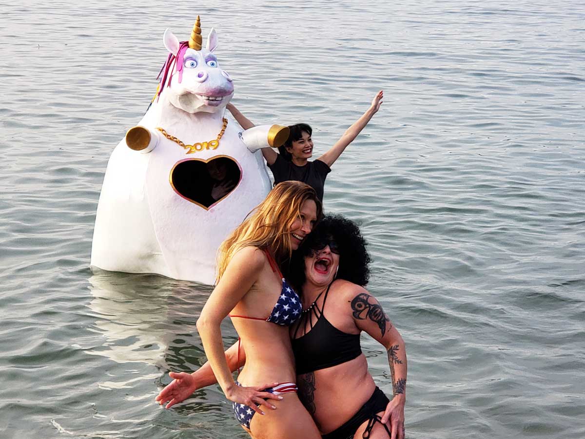 Participants posing with a unicorn float at the Polar Bear Swim.