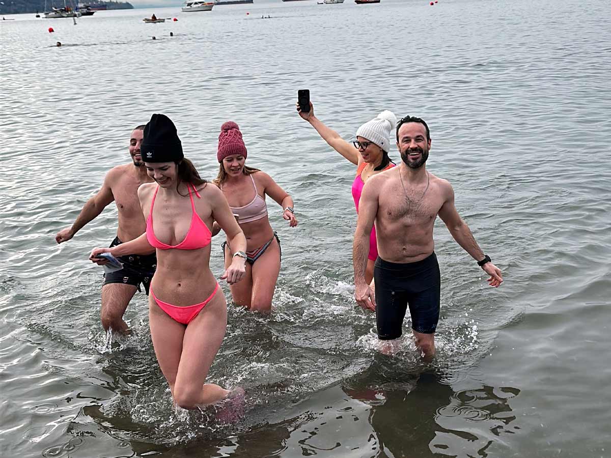 Smiling swimmers coming out of the water at the Polar Bear Swim.