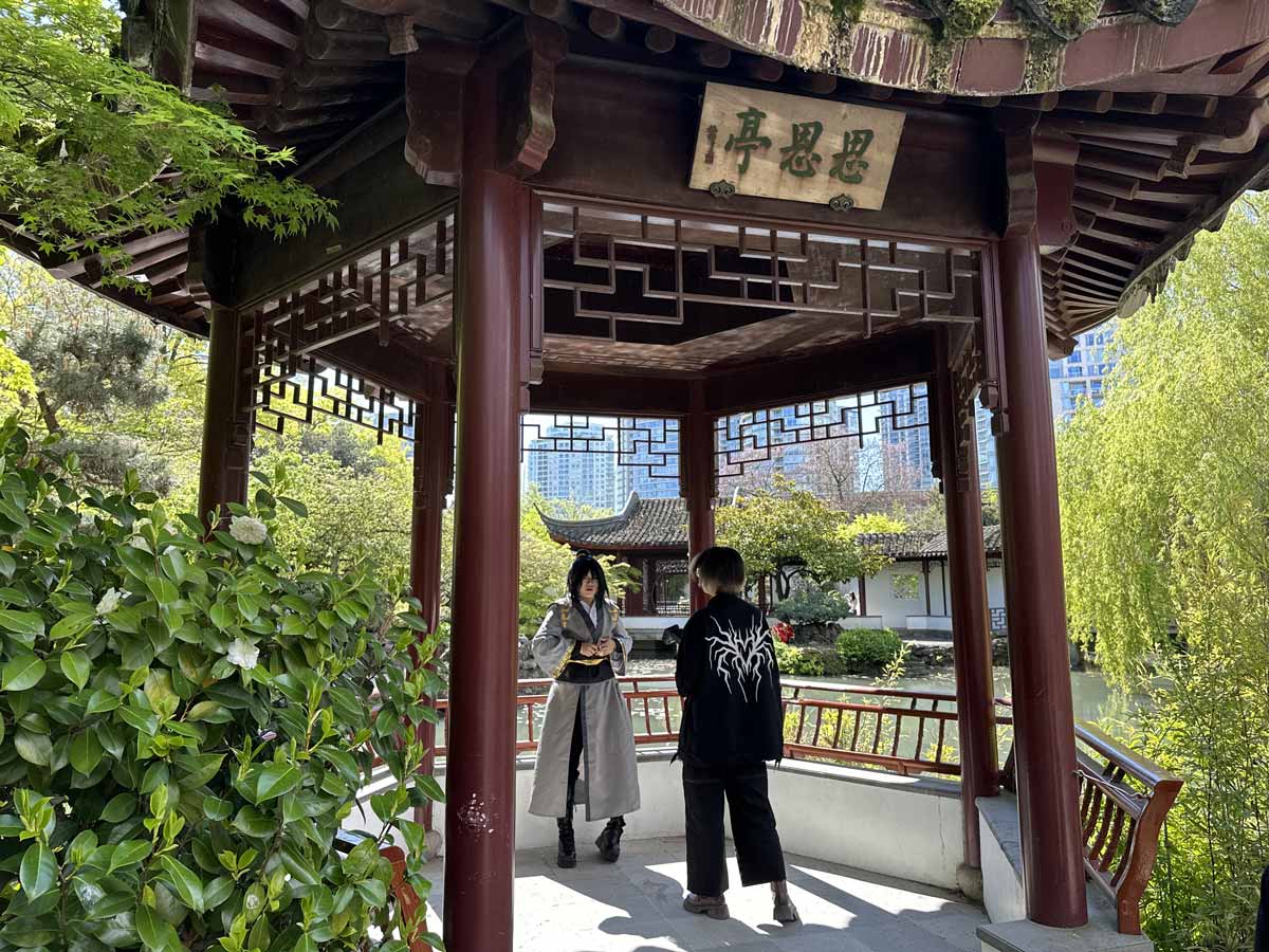 Visitors standing inside a pavilion at Dr. Sun Yat-Sen Garden.