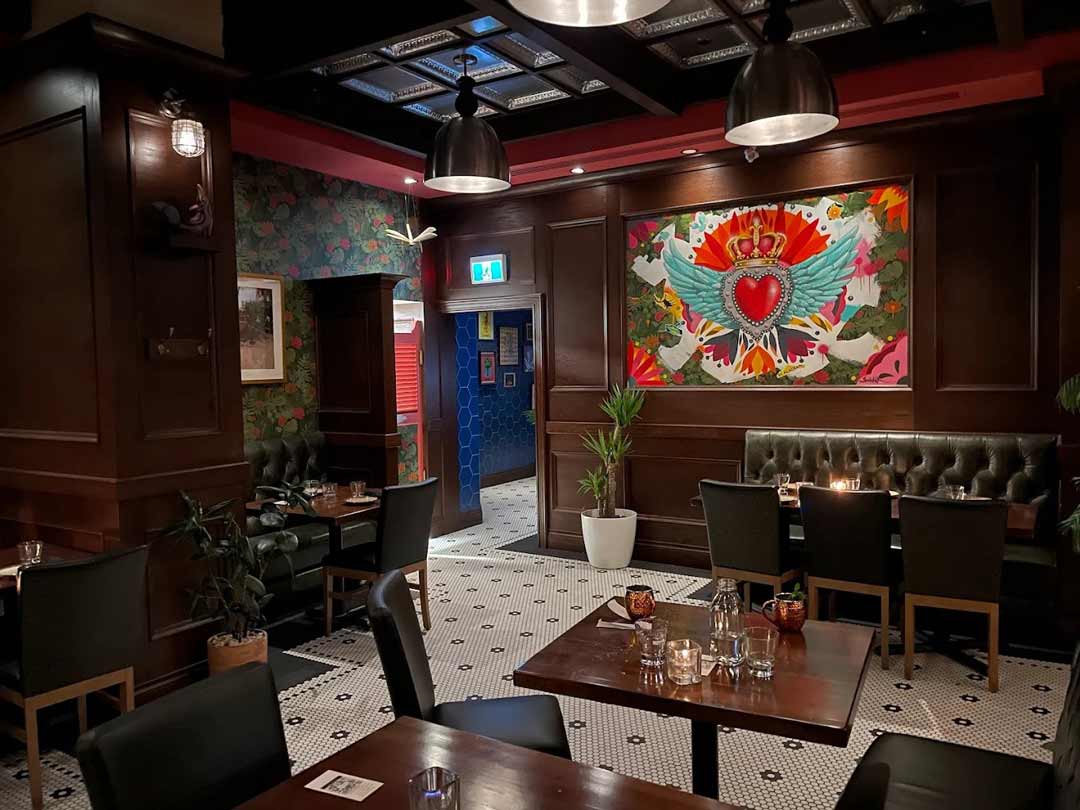 Dining area with heart-wing mural and cozy booth seating.