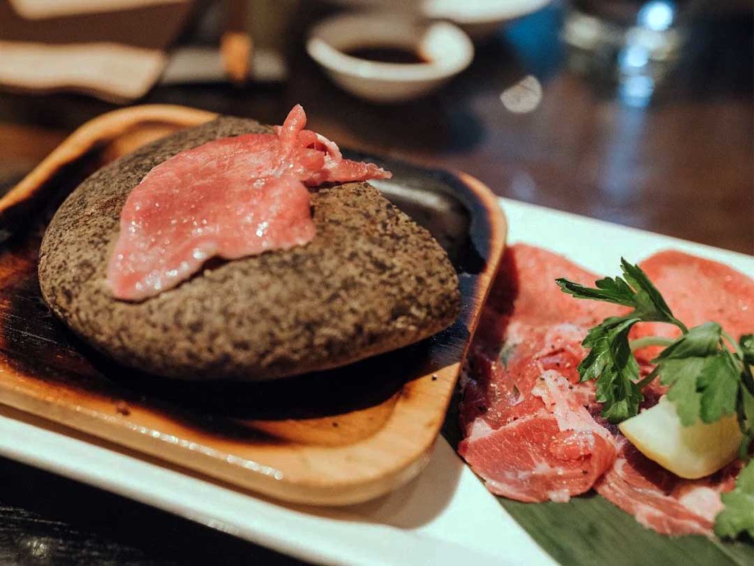 Stone-grilled Kobe beef slices on hot rock.