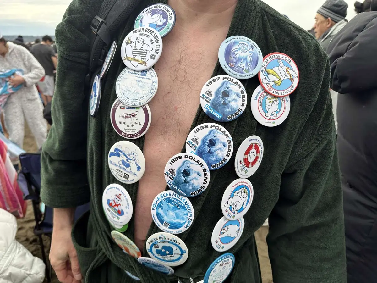 Participant wearing Polar Bear Swim Club badges at English Bay.